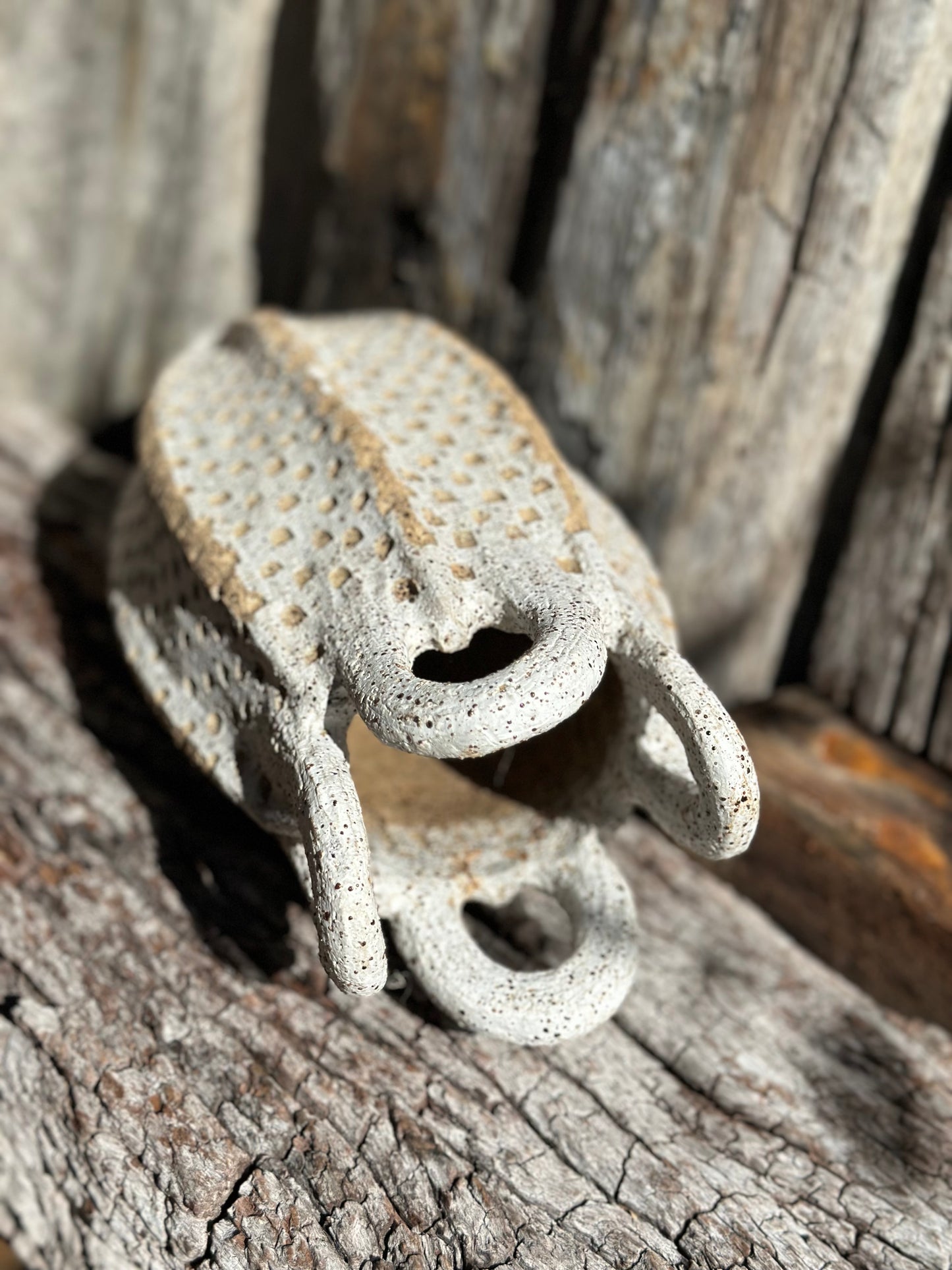 Detailed view of loop handles with iron-rich speckled clay and hand-carved grid surface on sculptural stoneware vessel by Heidi Dickinson