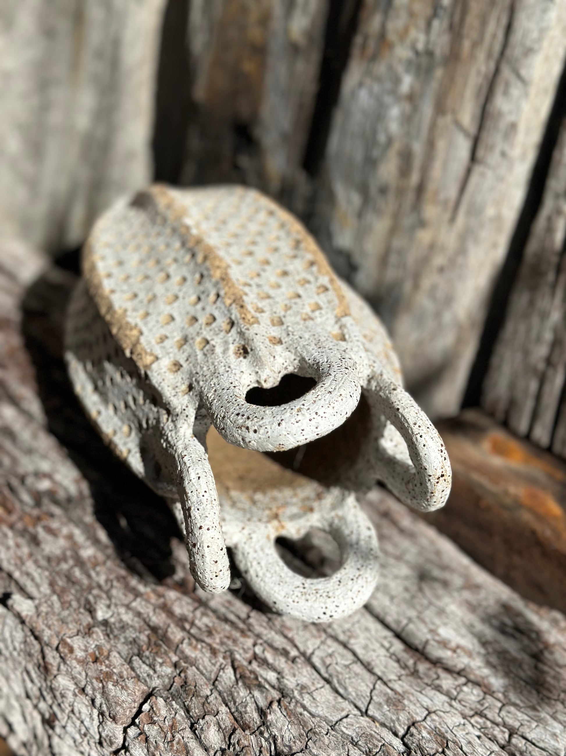 Detailed view of loop handles with iron-rich speckled clay and hand-carved grid surface on sculptural stoneware vessel by Heidi Dickinson