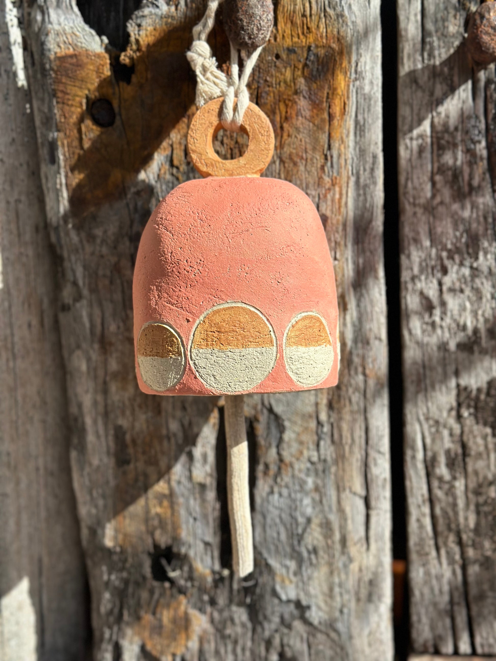 Stoneware bell hanging outdoors, indoors showcasing sculptural form and mid-century inspired design