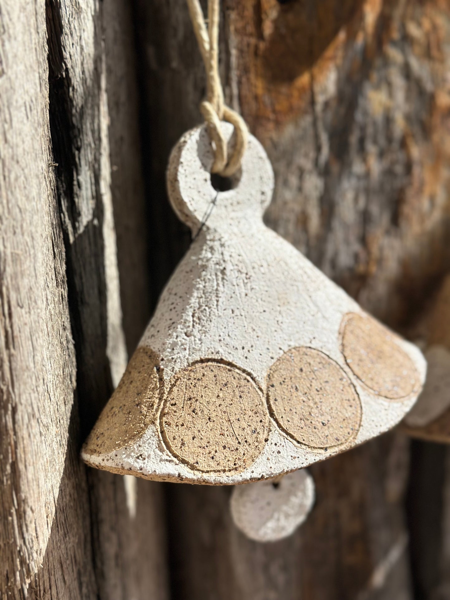 Close-up of ceramic hanging bell featuring carved white circles and natural BRT clay texture, by Heidi Dickinson – Denmark, WA