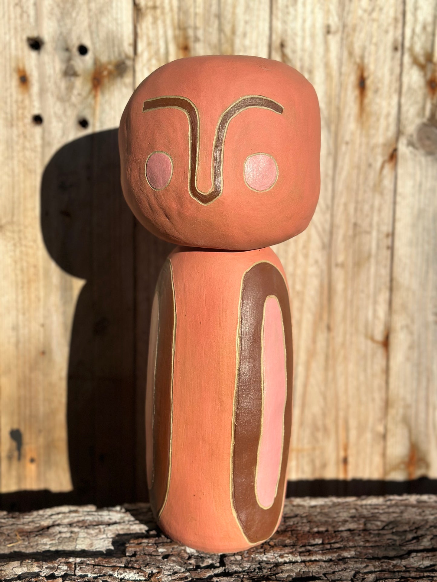 Front view of contemplative ceramic sculpture showing texture and subtle layering of warm-toned glazes
