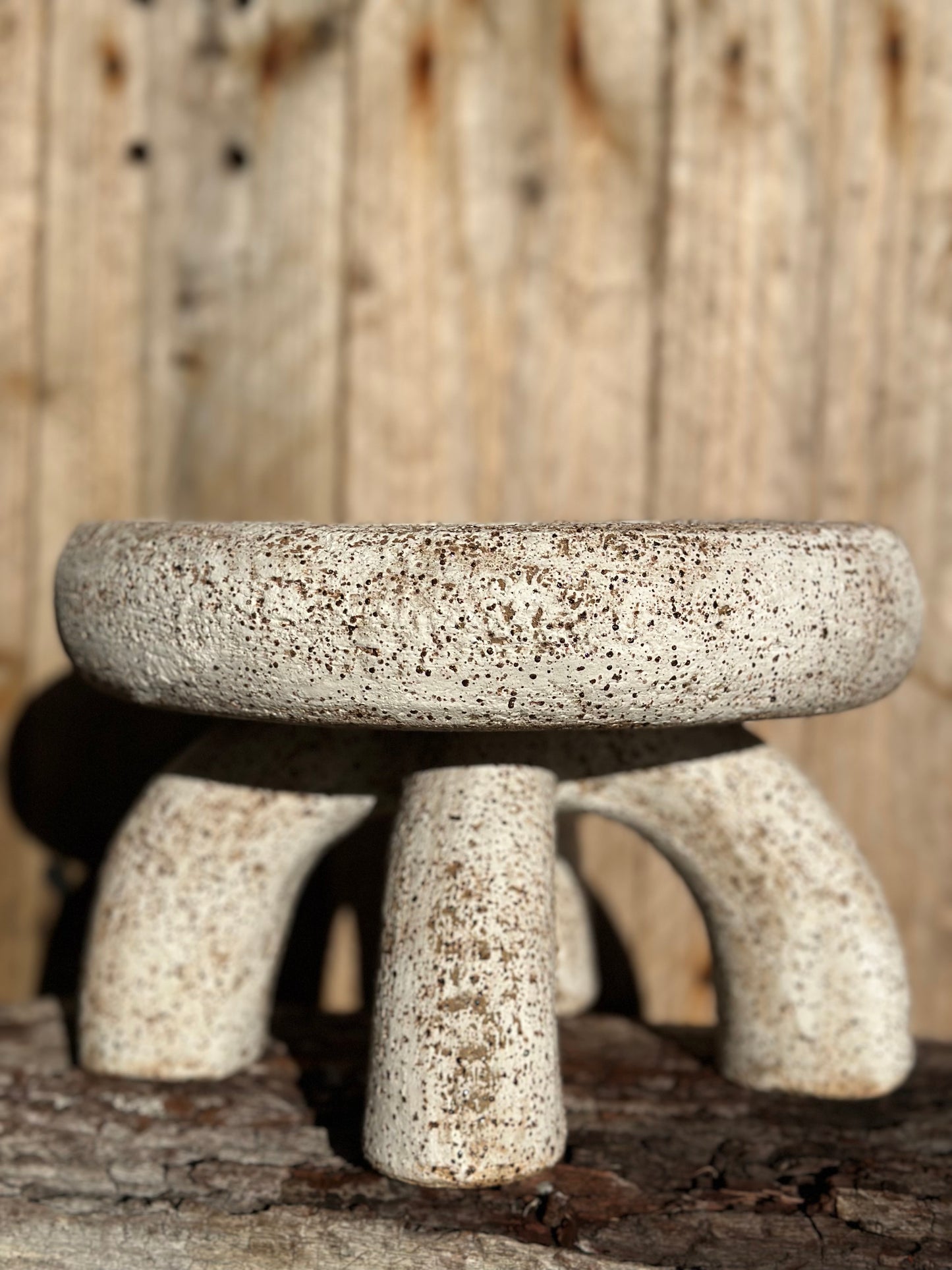 Hand-built two-part ceramic sculpture with shallow compressed bowl form on four curved legs, in matte white over raw speckled clay