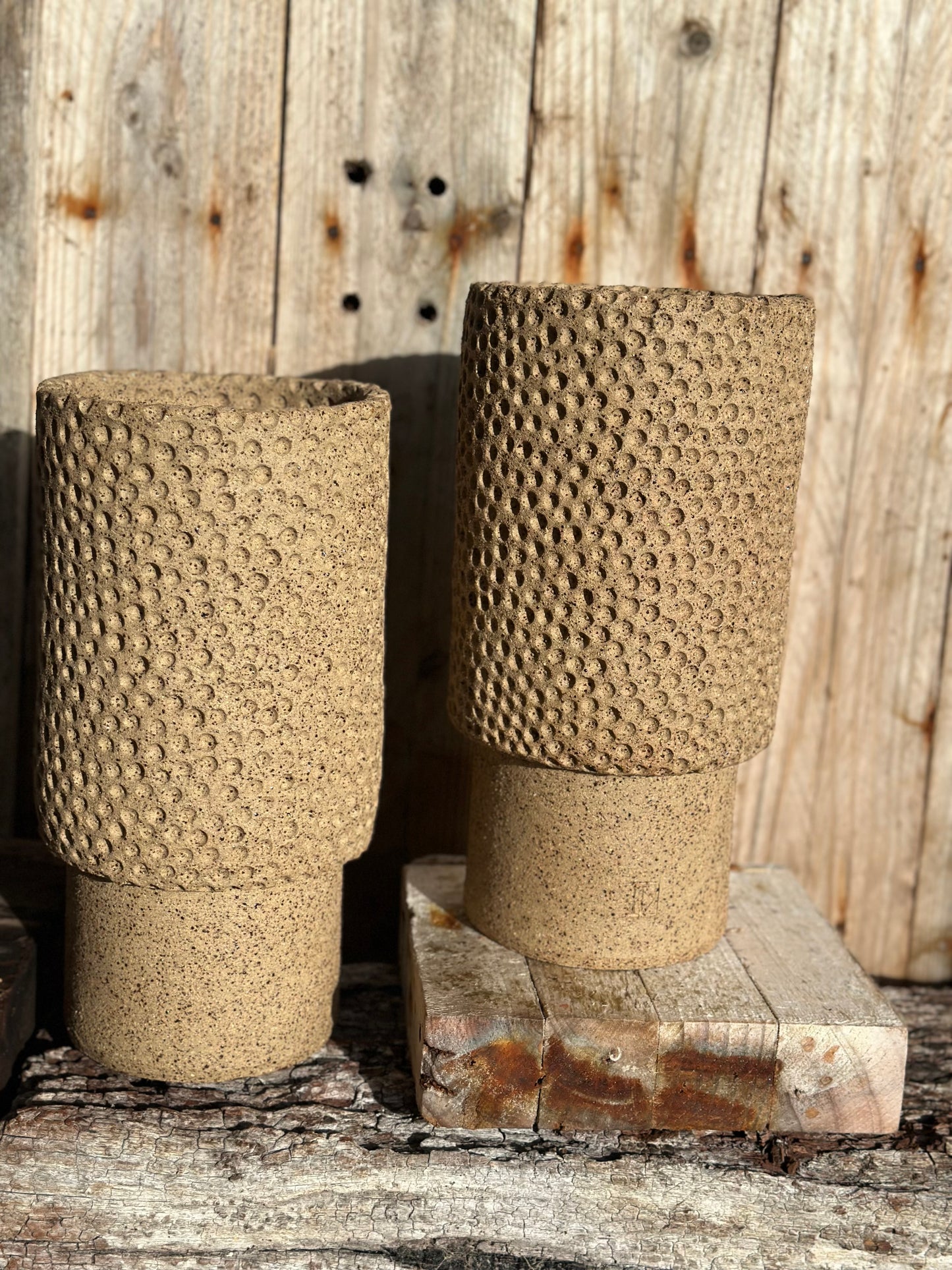 Detail of stippled relief texture on hand-built stoneware vessel showing raw clay surface and tactile finish