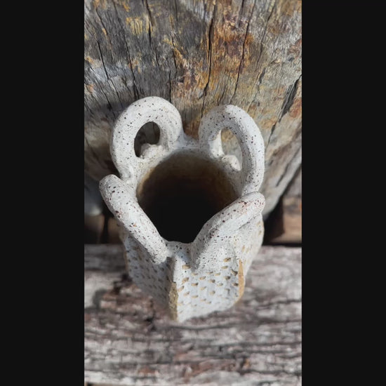 Short video begins on the textured surface, then zooms out to reveal the full stoneware vessel with looped handles and speckled finish