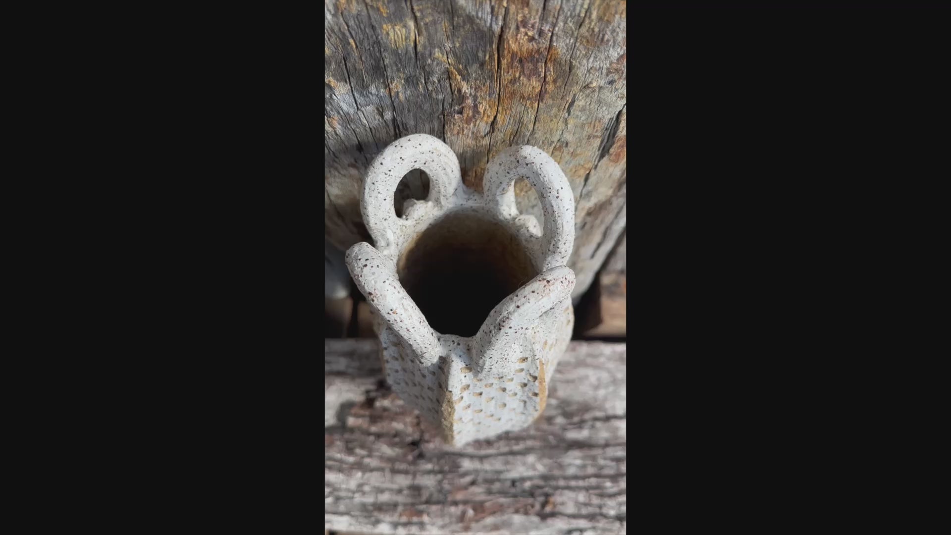 Short video begins on the textured surface, then zooms out to reveal the full stoneware vessel with looped handles and speckled finish