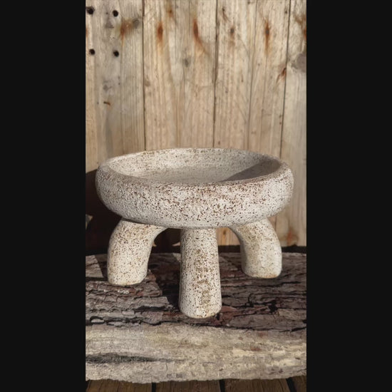 Short video   two-part ceramic vessel, showing compressed bowl form and arched supports with matte white glaze over gritty stoneware