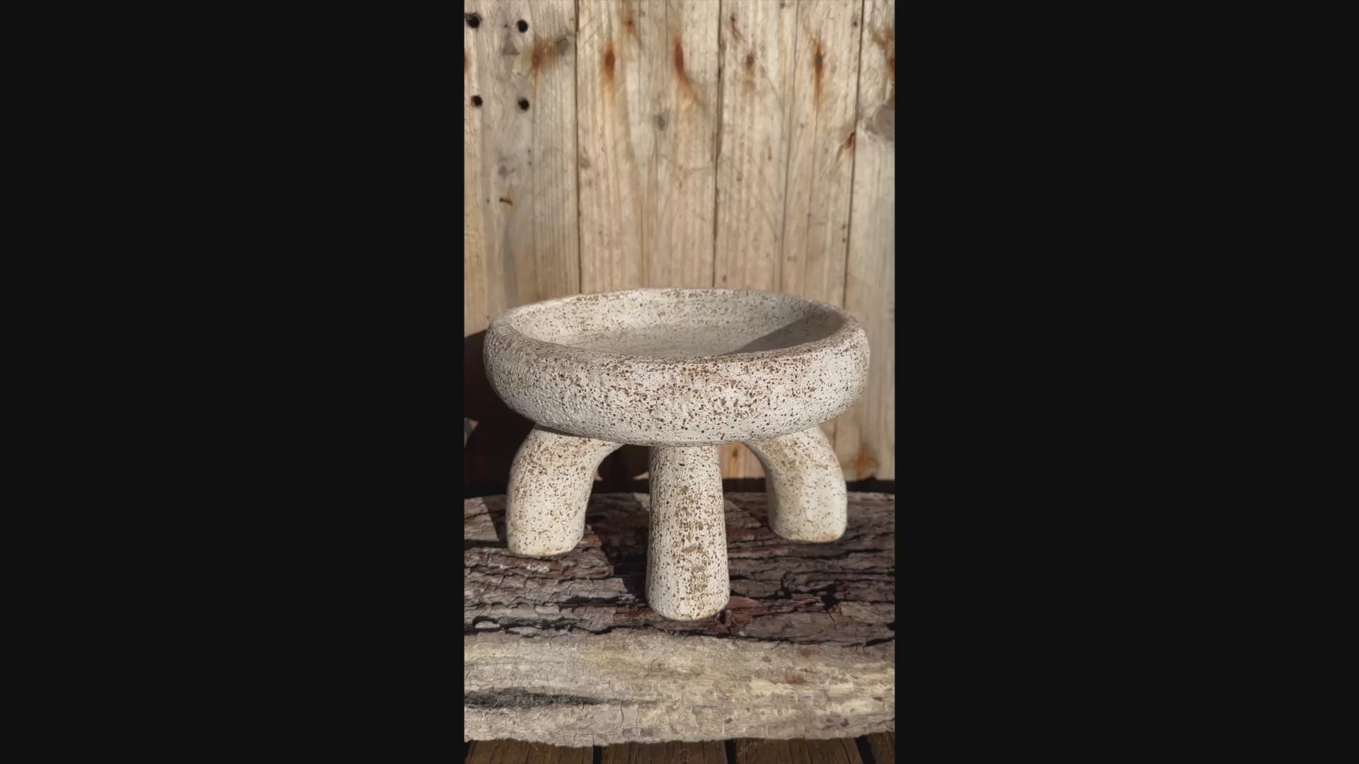 Short video   two-part ceramic vessel, showing compressed bowl form and arched supports with matte white glaze over gritty stoneware