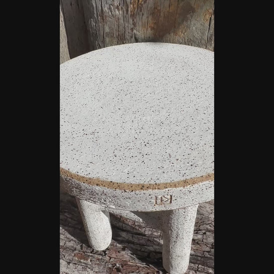 Short video Handmade ceramic stool with four legs, white underglaze, and exposed clay rim Handmade ceramic milking stool with white underglaze and exposed raw clay rim, shown in full view