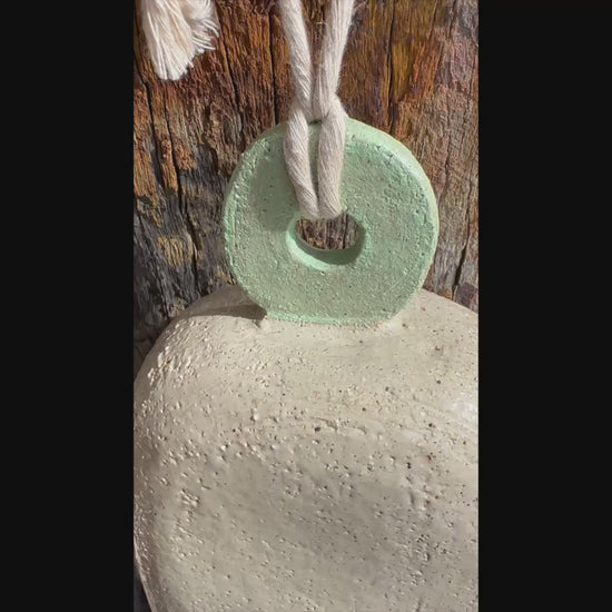 Handcrafted white stoneware bell with mint circular motif, Danish-inspired design by ceramic artist Heidi Dickinson