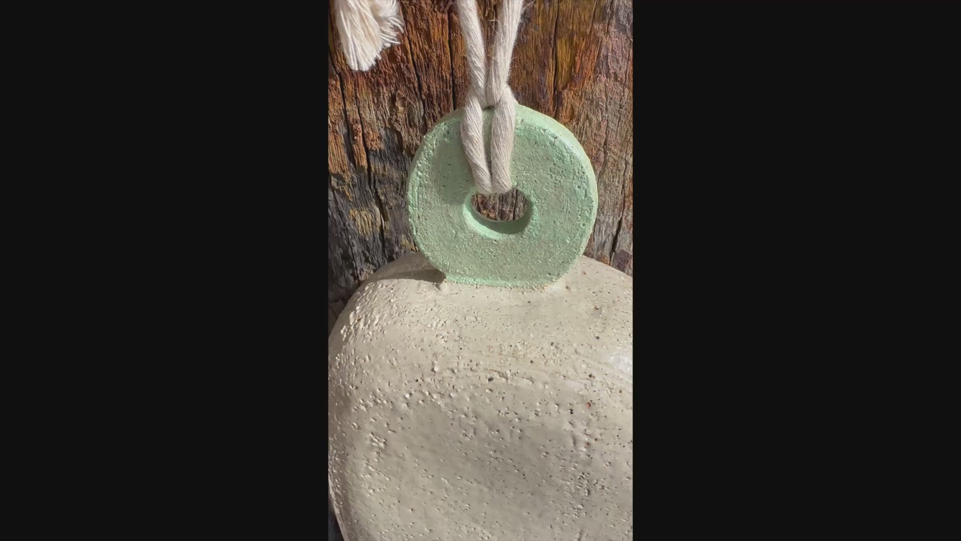 Handcrafted white stoneware bell with mint circular motif, Danish-inspired design by ceramic artist Heidi Dickinson